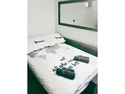 a bed in a room with a mirror and two pillows at Victoria's Place Apartment in Ljubljana