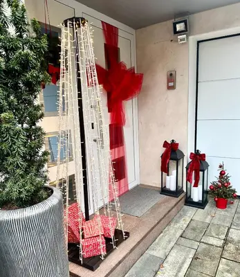 a porch decorated for christmas with red bows at Victoria's Place Apartment in Ljubljana