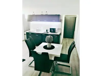 a kitchen with green cabinets and a white table and chairs at Victoria's Place Apartment in Ljubljana