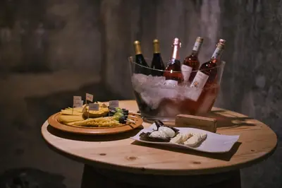 a table with bottles of wine and cheese and food at House On The Hill (Hiška Na Griču) in Spodnja Idrija