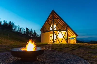 a fire pit in front of a small house at House On The Hill (Hiška Na Griču) in Spodnja Idrija