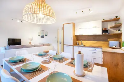 a dining room and kitchen with a table and chairs at Alpine Home Apartment in Bohinj