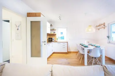 a white living room with a white couch and a table at Alpine Home Apartment in Bohinj