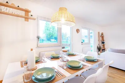 a dining room with a table and chairs and a chandelier at Alpine Home Apartment in Bohinj