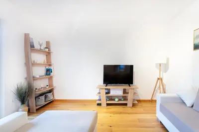 a living room with a couch and a tv on a table at Alpine Home Apartment in Bohinj