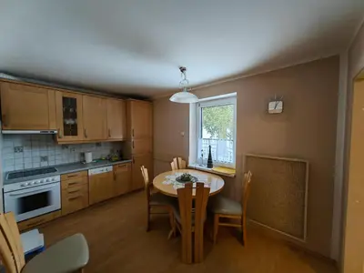 a kitchen with a table and a table and chairs at Apartment Ski Sara Pokljuka in Bled