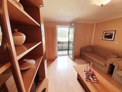 a living room with a couch and a table at Apartment Ski Sara Pokljuka in Bled