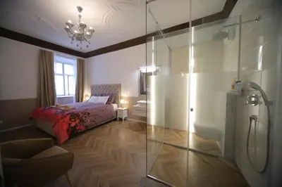 a bedroom with a bed and a glass shower at Vitez Apartment I in Ljubljana