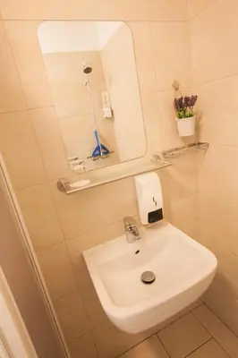 a bathroom with a white sink and a mirror at Rooms Klik Postojna in Postojna