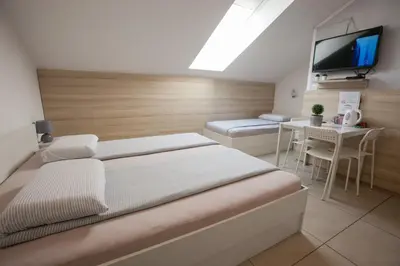 a bedroom with a bed and a table and a tv at Rooms Klik Postojna in Postojna