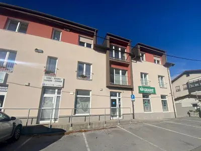 a large building with a car parked in front of it at Rooms Klik Postojna in Postojna