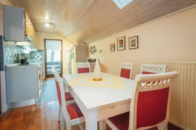 a kitchen and dining room with a white table and chairs at Apartma BOROVC in Mojstrana