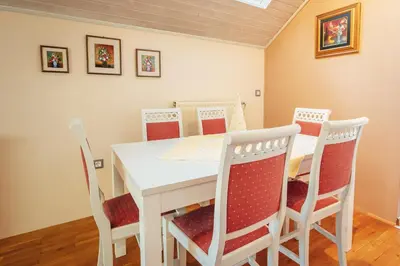 a dining room with a white table and chairs at Apartma BOROVC in Mojstrana