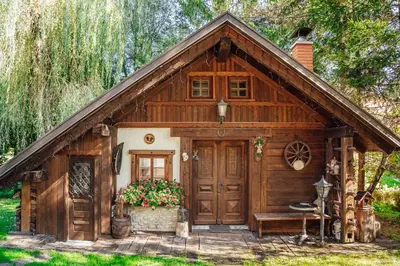 a wooden cabin with a bench and a door at Apartma BOROVC in Mojstrana