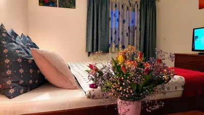 a living room with a couch with a vase of flowers at Rooms Ravnik in Bled