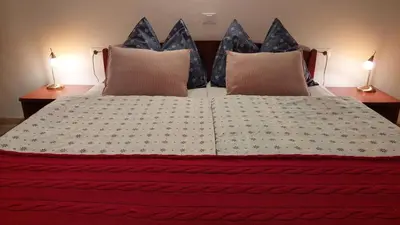 a bedroom with a bed with two lamps on both sides at Rooms Ravnik in Bled