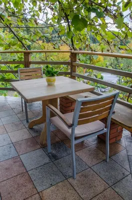 a wooden table and chairs on a patio at Miškar Rooms in Cerknica