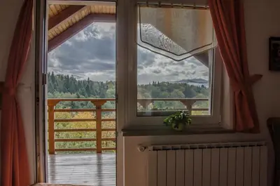 a window with a view of a wooden deck at Miškar Rooms in Cerknica