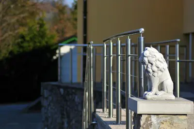 a statue of a lion standing next to a gate at Pension Patrik in Hrušica
