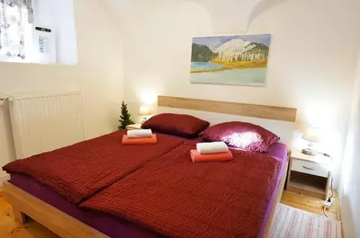 a bedroom with a red bed with two pillows on it at Jacobs Resort 4 Bedroom Private House in Kranjska Gora