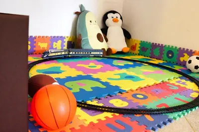 two stuffed penguins and a toy train on a rug at Jacobs Resort 4 Bedroom Private House in Kranjska Gora