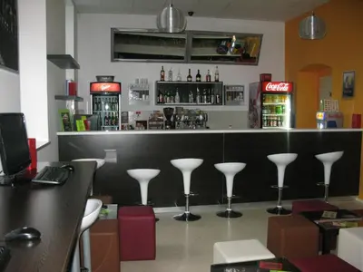 a bar with a row of stools in a restaurant at Youth Hostel Krško in Krško