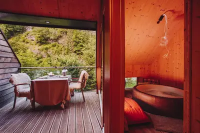 a room with a table and a tub on a deck at House Raduha in Luče