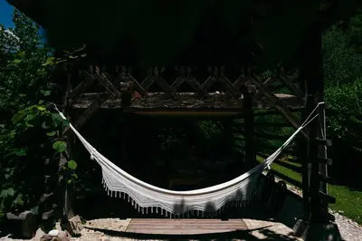 a hammock hanging from a wooden bridge at House Raduha in Luče
