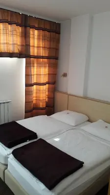 two white beds in a room with a window at Rooms K in Maribor