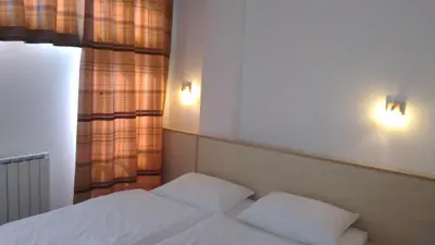 a bedroom with two white beds and a window at Rooms K in Maribor