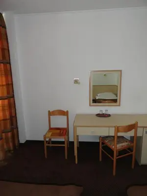 a room with a table and two chairs and a mirror at Rooms K in Maribor