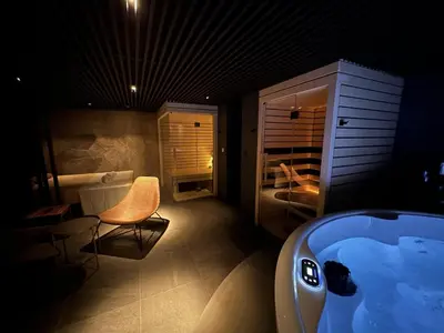 a bathroom with a tub and a chair and a bed at Boutique & Wellness Hotel Vital in Moravske Toplice