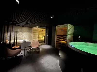 a bathroom with a tub and a table and chairs at Boutique & Wellness Hotel Vital in Moravske Toplice