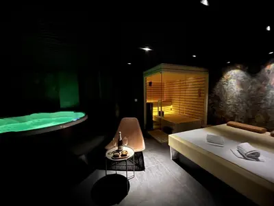 a bedroom with a bed and a bath room with a tub at Boutique & Wellness Hotel Vital in Moravske Toplice