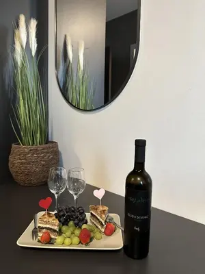 a plate of food with a bottle of wine and wine glasses at Boutique & Wellness Hotel Vital in Moravske Toplice