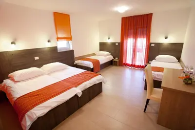a hotel room with two beds and a desk at Guesthouse Ošterija in Branik