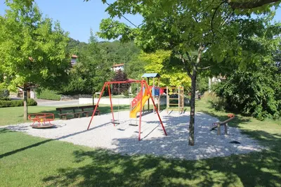 a playground in a park with a tree at Guesthouse Ošterija in Branik