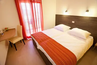 a hotel room with a bed and a desk and a window at Guesthouse Ošterija in Branik