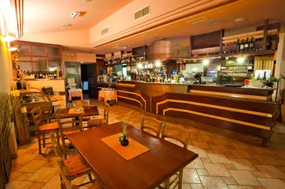 a restaurant with tables and chairs and a bar at Guesthouse Ošterija in Branik