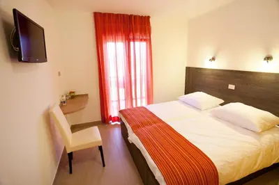 a bedroom with a bed and a desk and a television at Guesthouse Ošterija in Branik