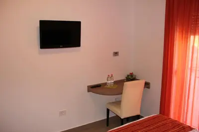 a small room with a table and a television on the wall at Guesthouse Ošterija in Branik