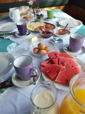 a table topped with plates of food and cups of coffee at Tourist Farm Ljubica in Poljane nad Škofjo Loko