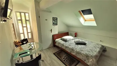 a small bedroom with a bed and a glass table at Guesthouse Sobe Silva in Tolmin