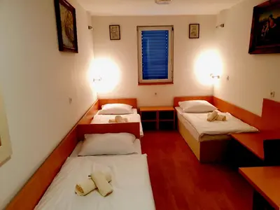 a room with three beds in it with a window at Hotel Galaksija Trebnje in Trebnje