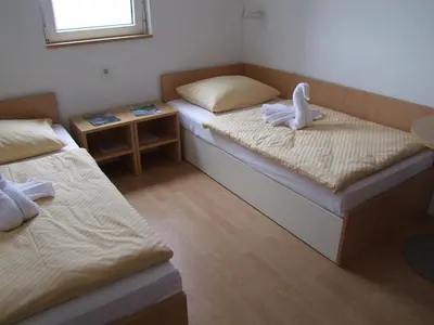 a room with two beds and a small table at Hotel Galaksija Trebnje in Trebnje