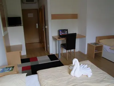 a room with a bed and a desk with a computer at Hotel Galaksija Trebnje in Trebnje