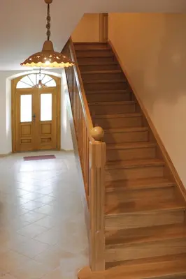 a stairway with a wooden rail and a door at Apartments Janks in Vremski Britof