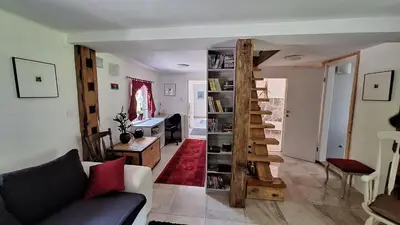 a living room with a couch and a book shelf at Divine Lake House in Motnik