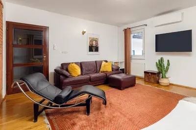 a living room with a couch and a chair at HoMEMADE in Ljubljana