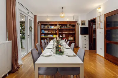 a long dining room with a white table and chairs at HoMEMADE in Ljubljana